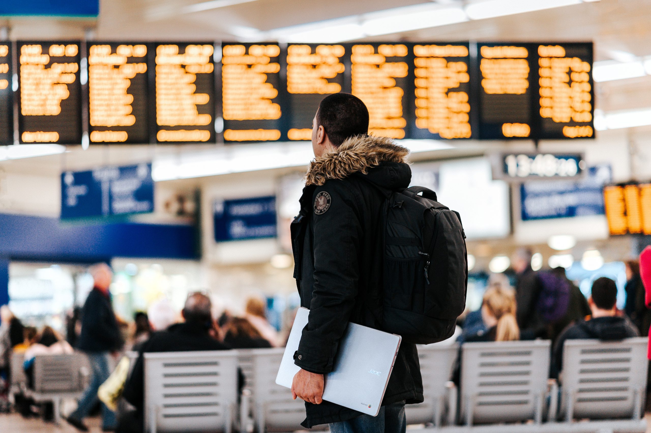 Man with laptop in airport departure hall